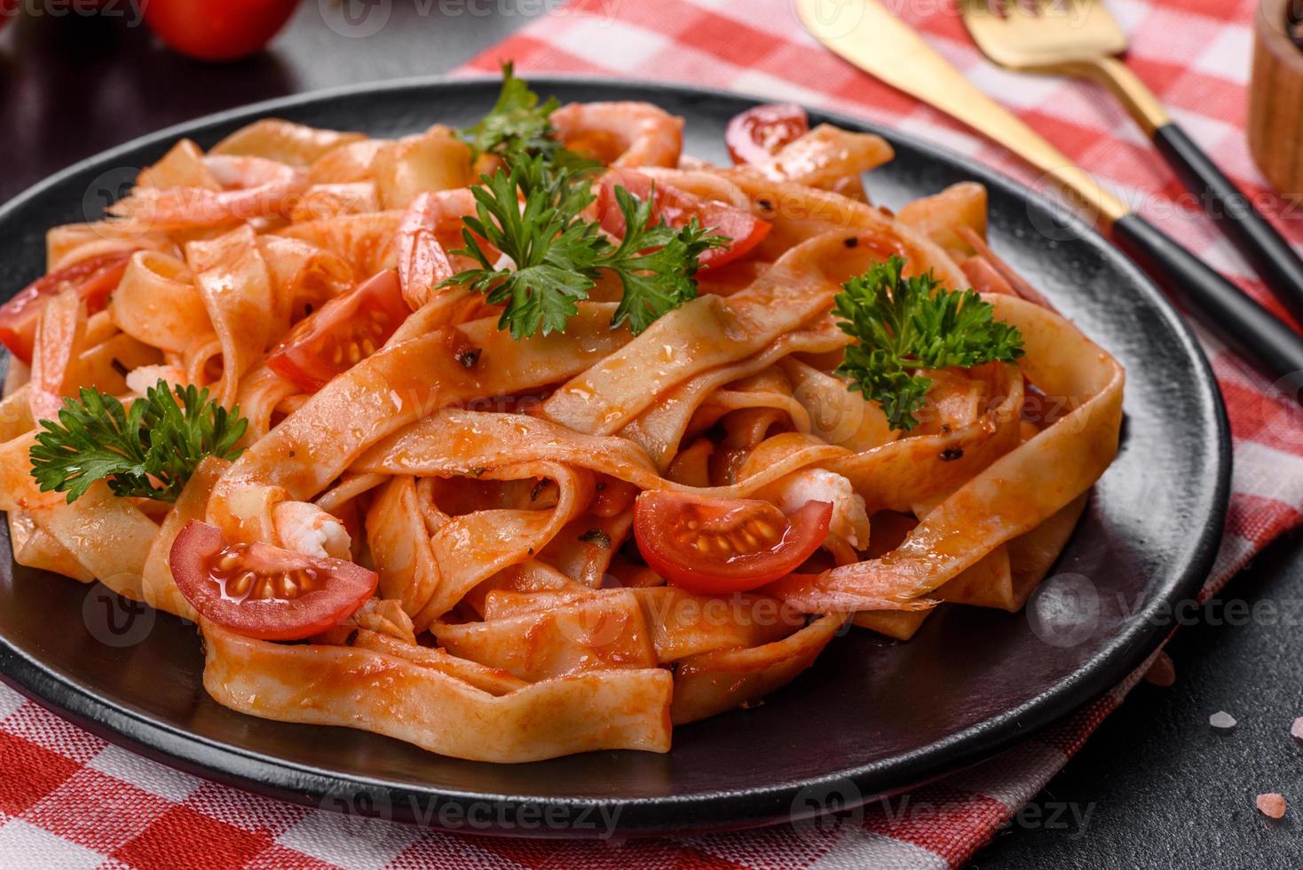 fettuccine con gamberi, pomodorini, salsa, spezie ed erbe aromatiche foto