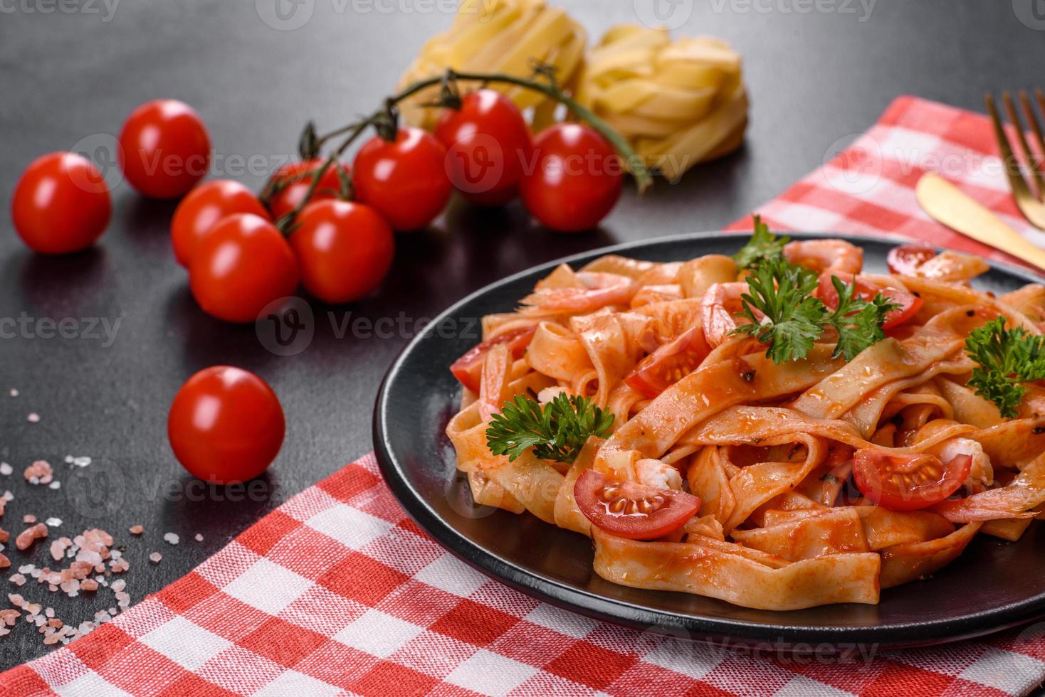 fettuccine con gamberi, pomodorini, salsa, spezie ed erbe aromatiche foto