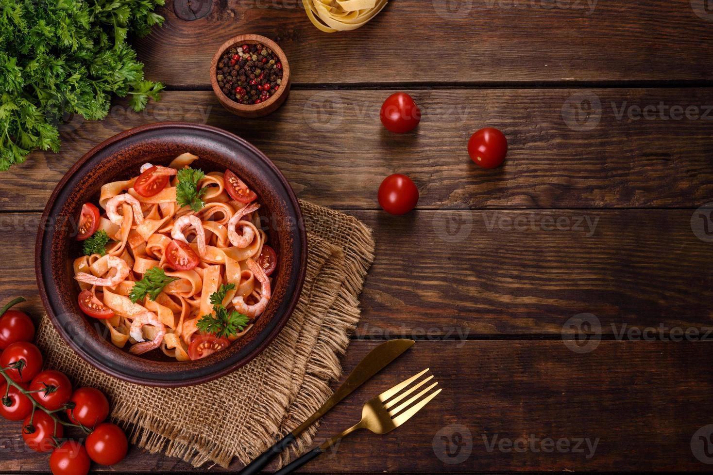 fettuccine con gamberi, pomodorini, salsa, spezie ed erbe aromatiche foto