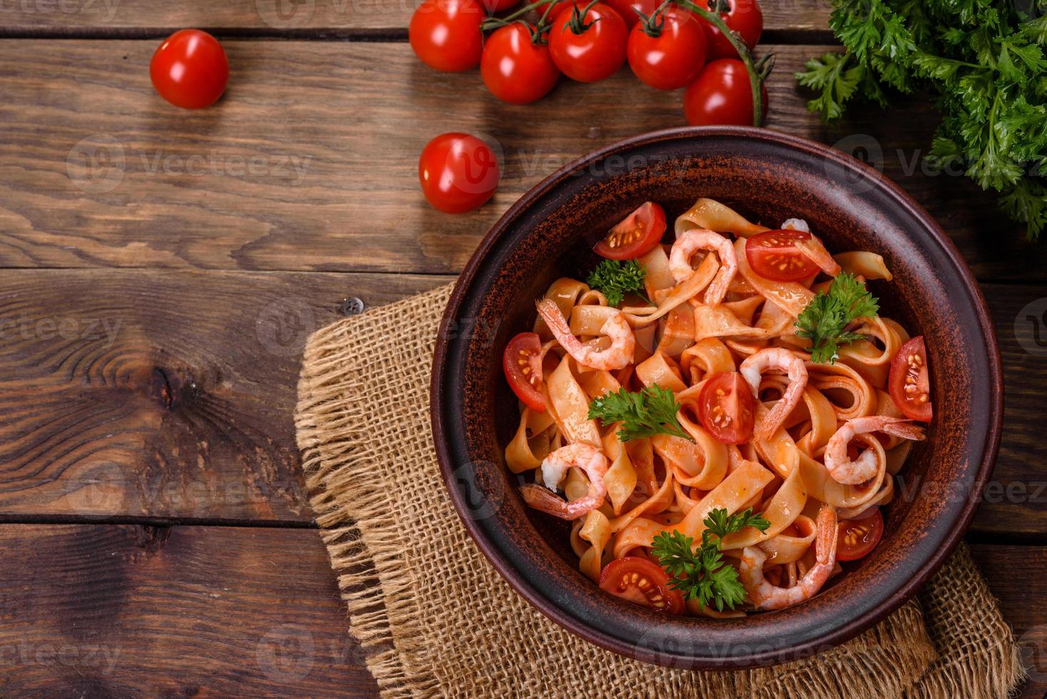 fettuccine con gamberi, pomodorini, salsa, spezie ed erbe aromatiche foto