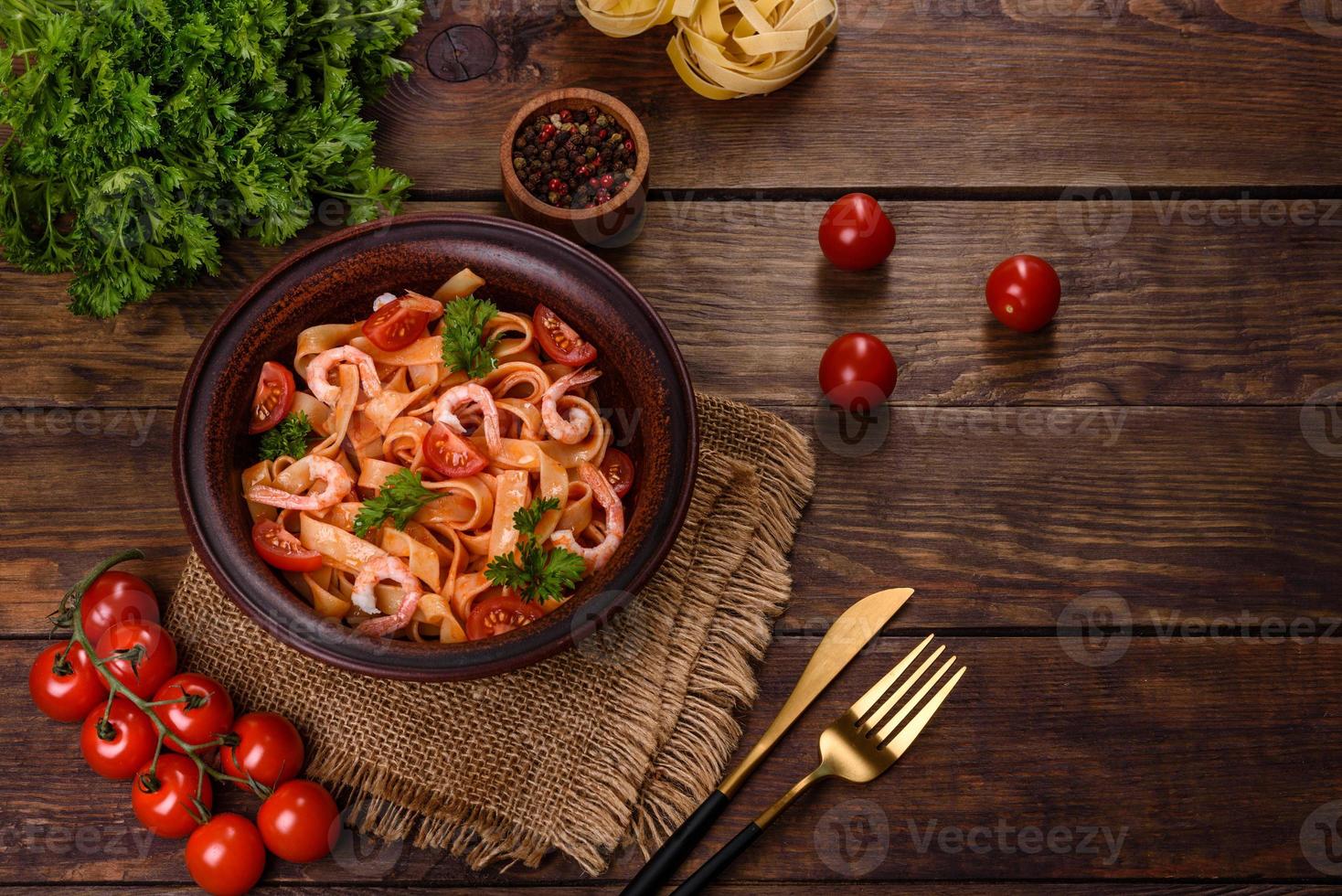 fettuccine con gamberi, pomodorini, salsa, spezie ed erbe aromatiche foto