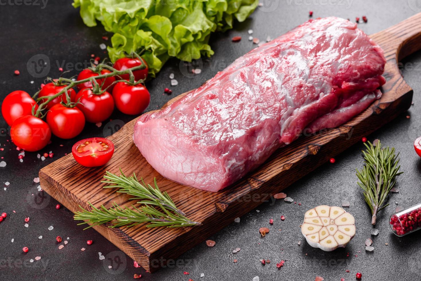 pezzi di maiale freschi pronti da cucinare su uno sfondo scuro in cucina foto