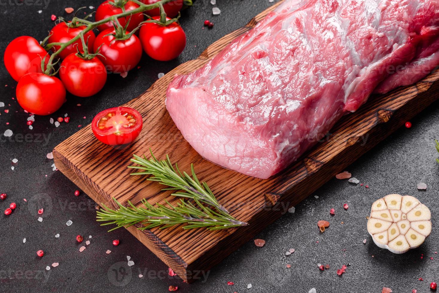 pezzi di maiale freschi pronti da cucinare su uno sfondo scuro in cucina foto