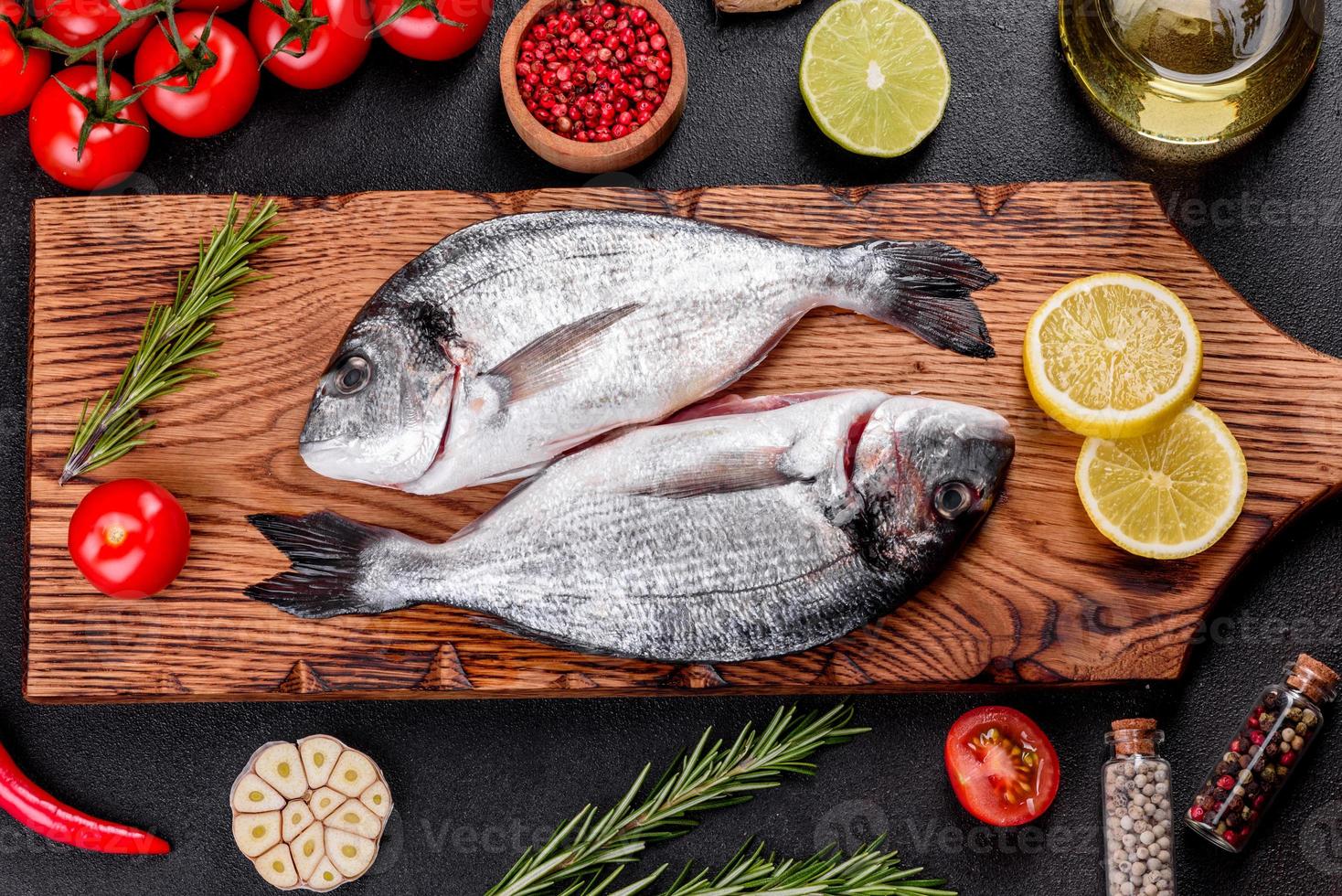 pesce dorado crudo con spezie cucinato sul tagliere foto