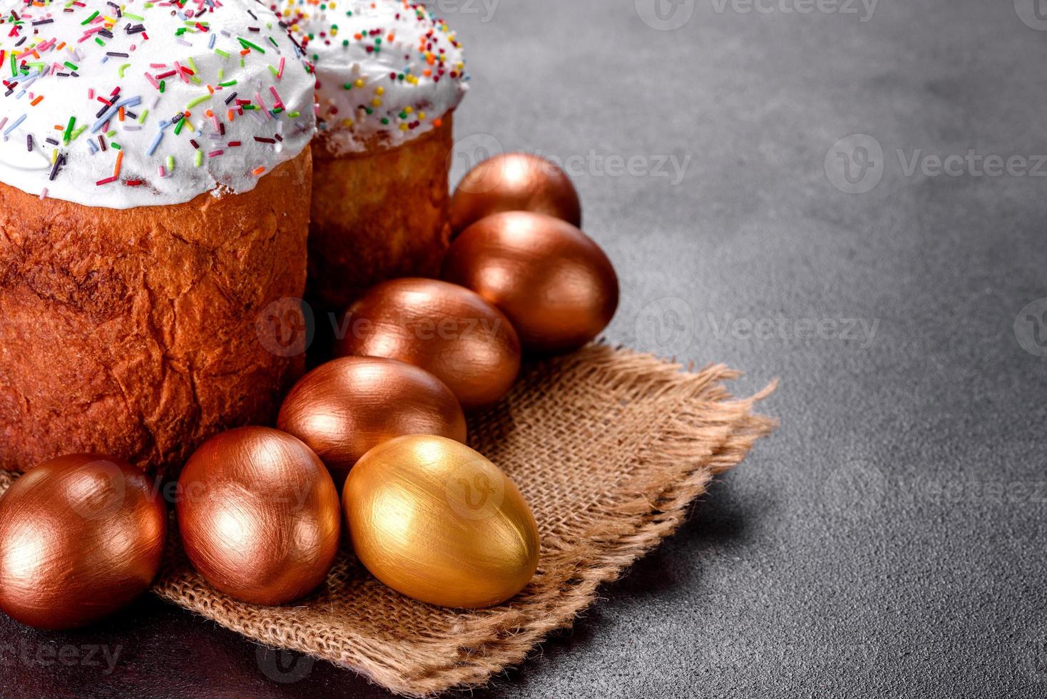 uova di pasqua oro e bronzo e torta di pasqua su sfondo scuro foto