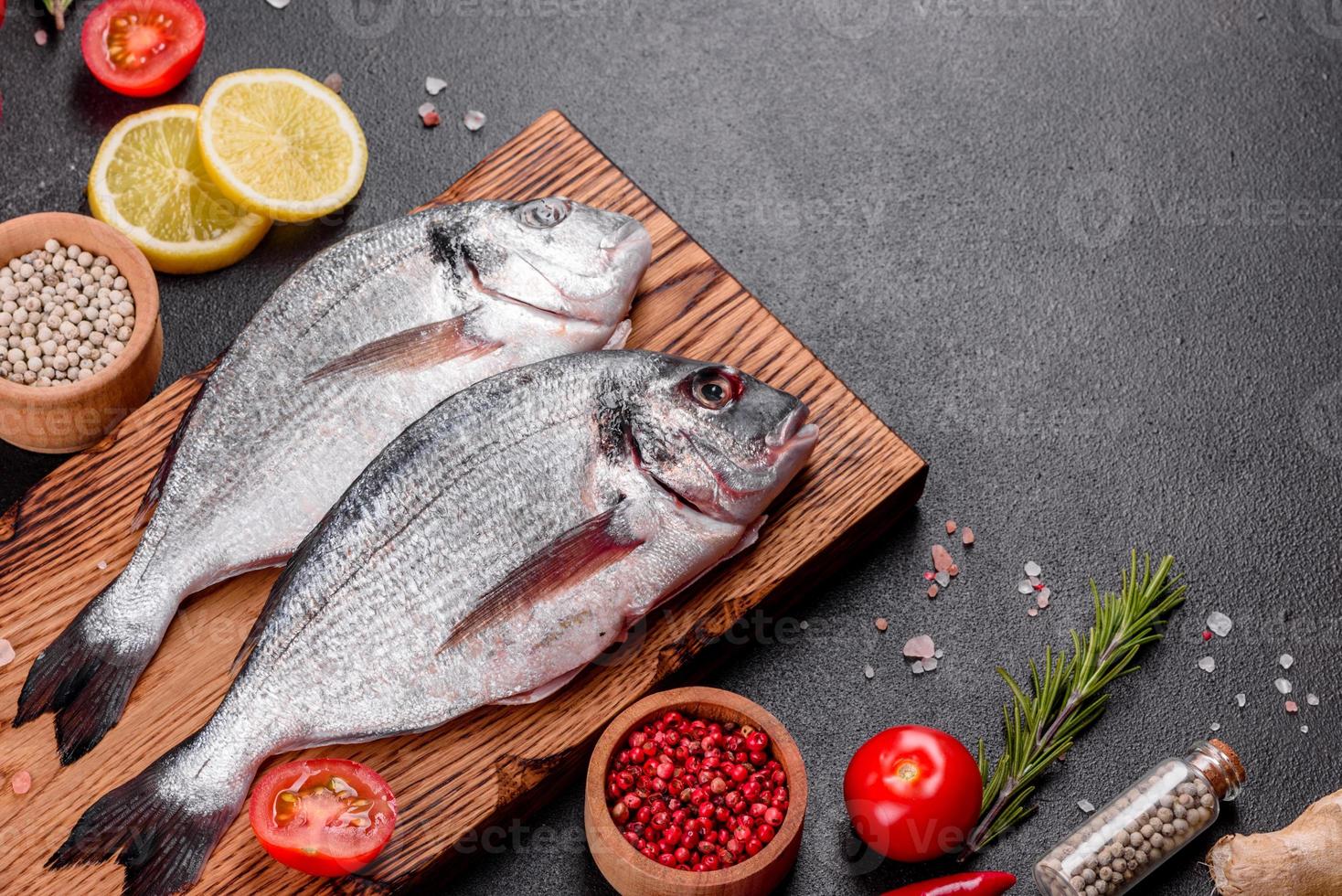 pesce dorado crudo con spezie cucinato sul tagliere foto