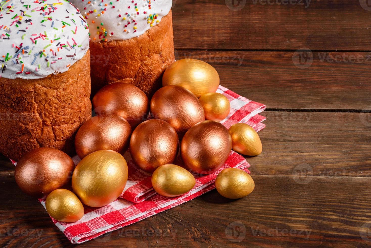 uova di pasqua oro e bronzo e torta di pasqua su sfondo scuro foto