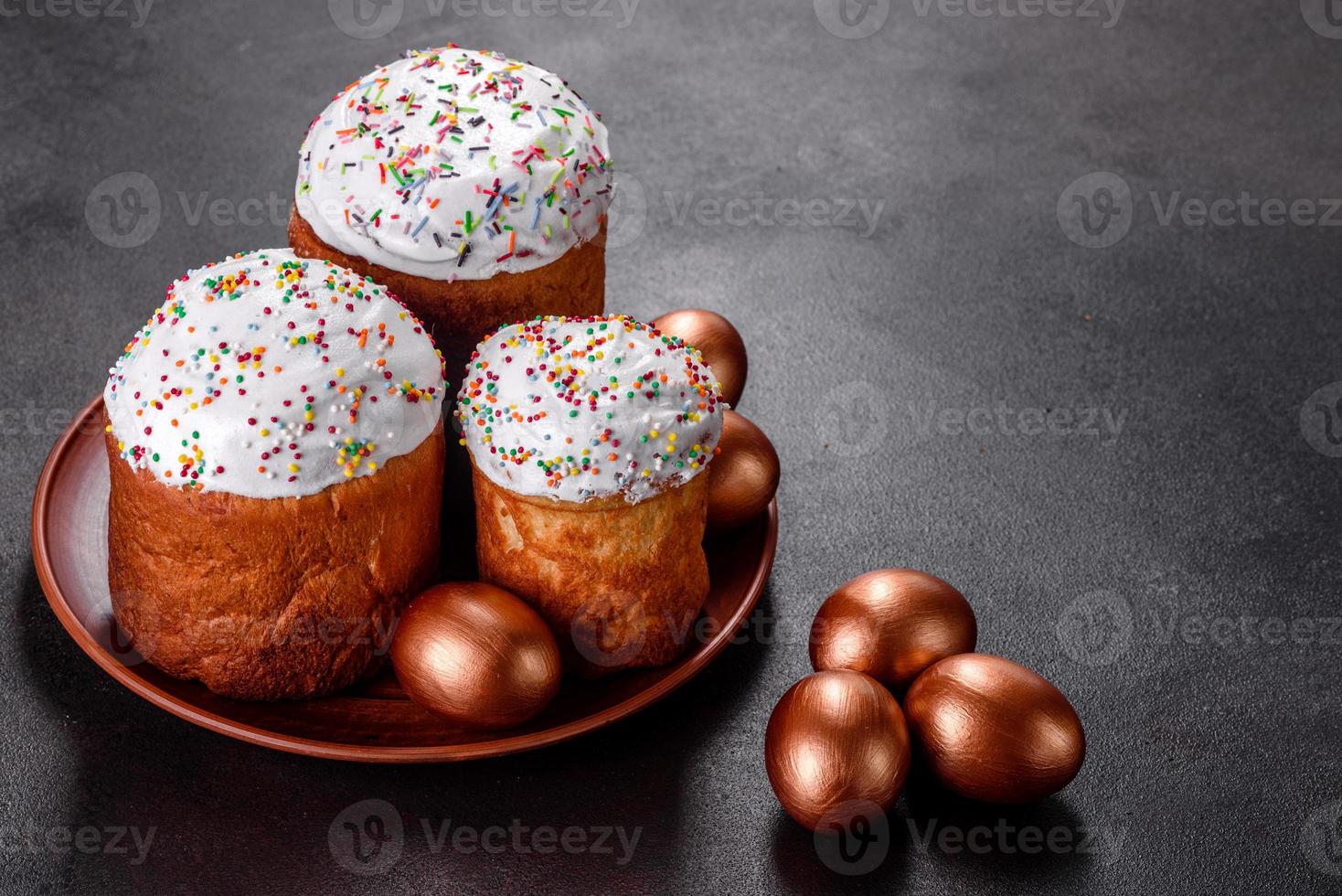 uova di pasqua oro e bronzo e torta di pasqua su sfondo scuro foto