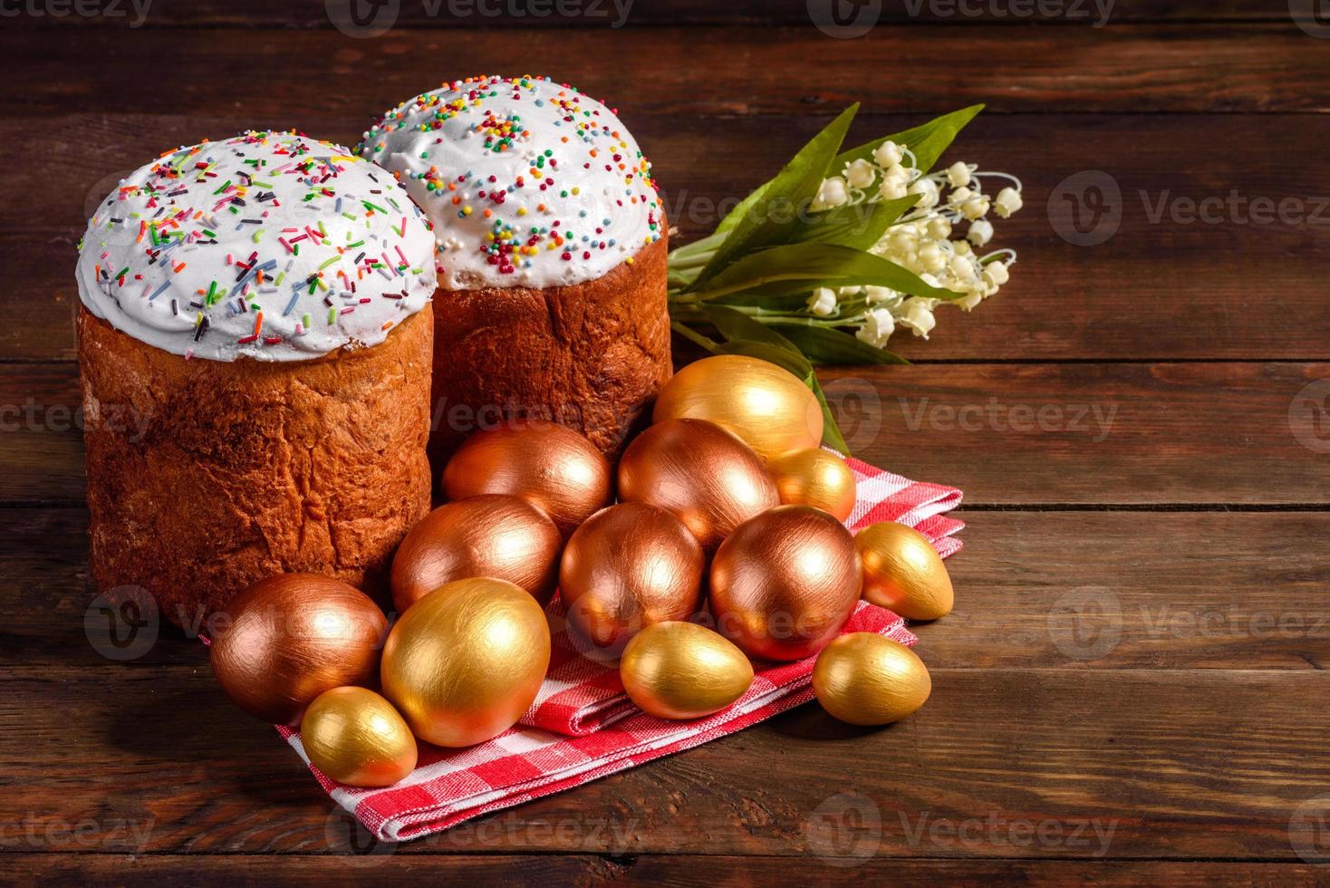 uova di pasqua oro e bronzo e torta di pasqua su sfondo scuro foto