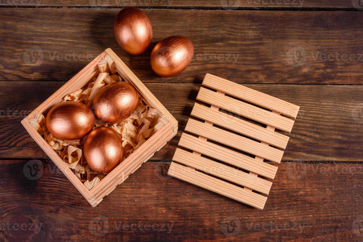 uova di pasqua in scatola regalo di legno su fondo di legno scuro foto