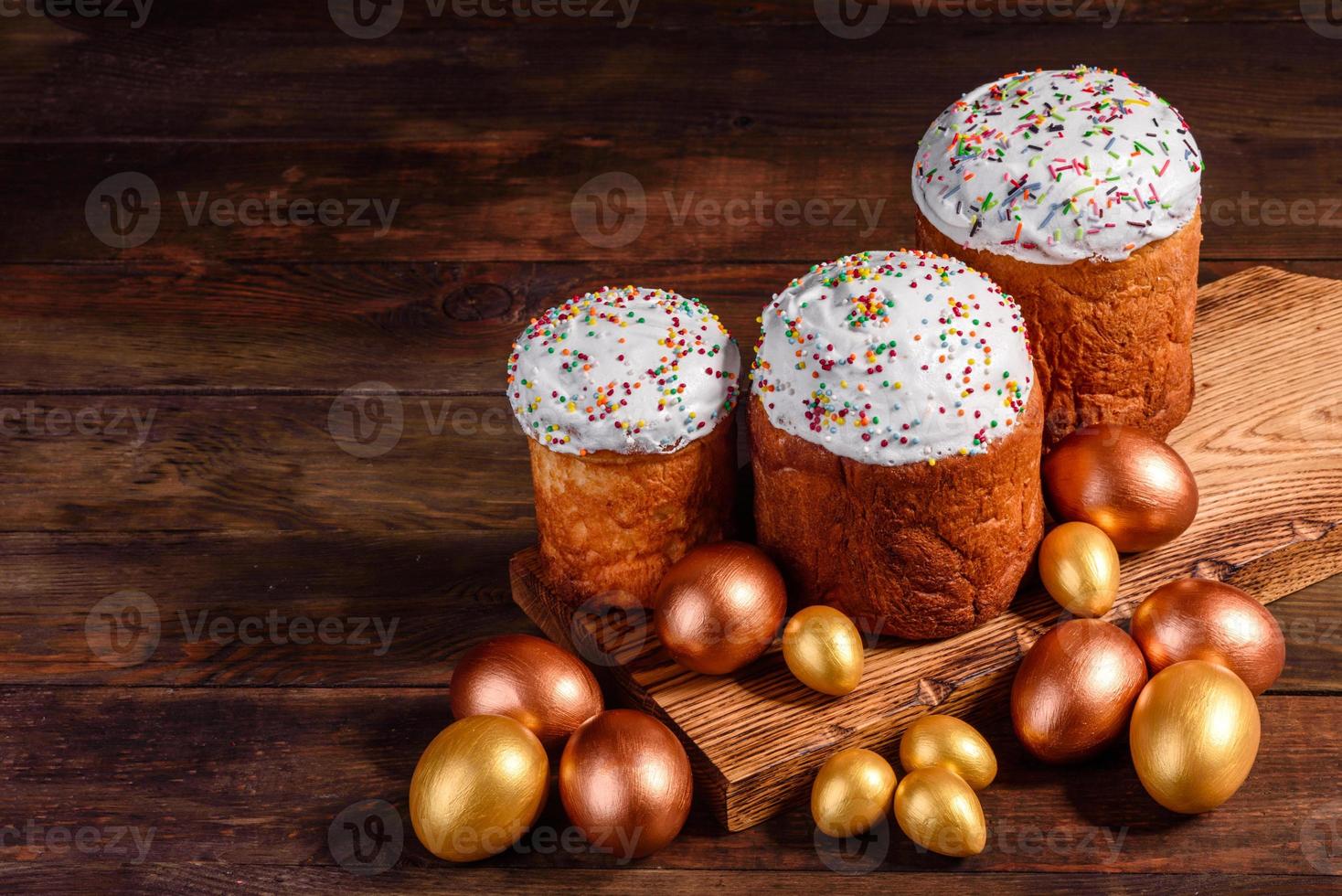 uova di pasqua oro e bronzo e torta di pasqua su sfondo scuro foto