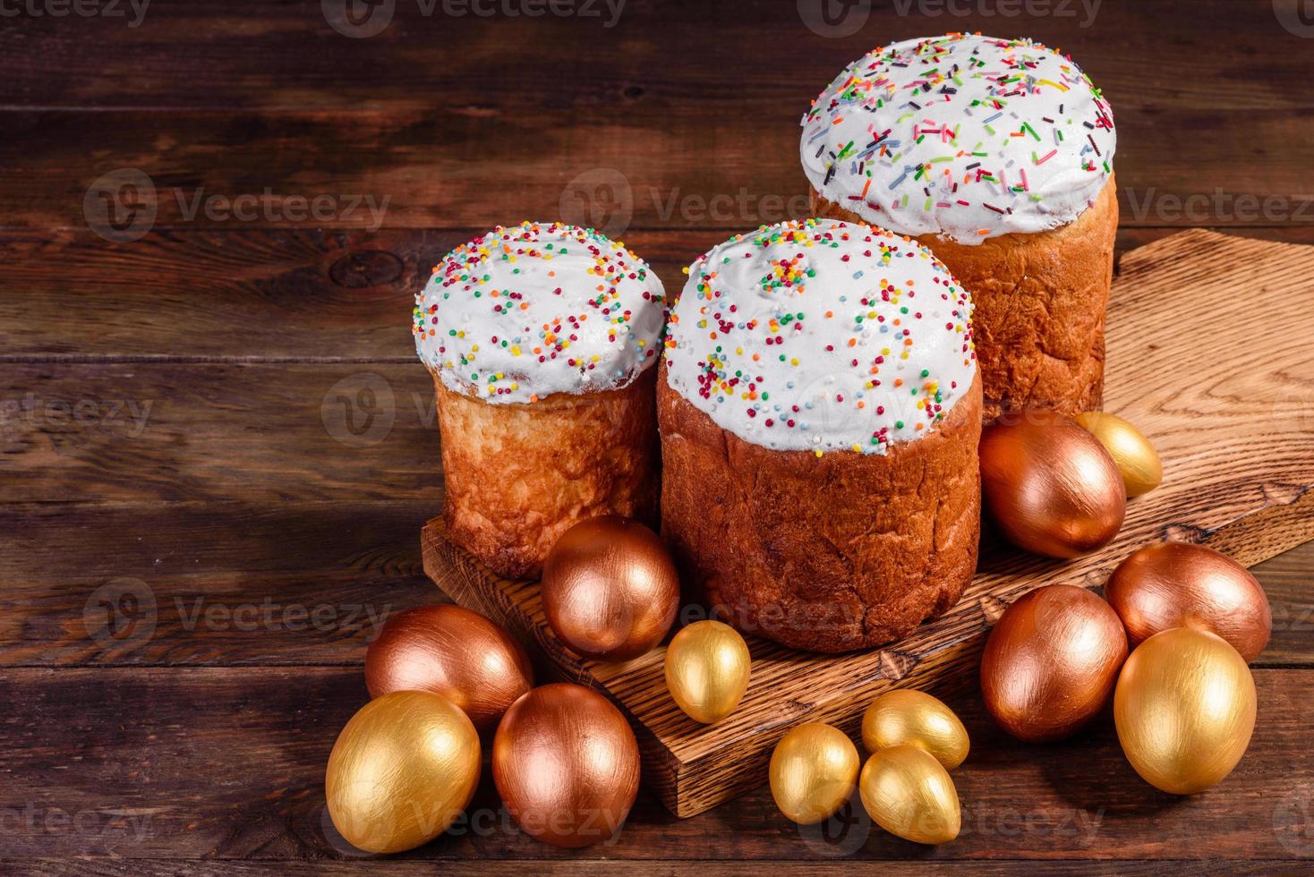 uova di pasqua oro e bronzo e torta di pasqua su sfondo scuro foto