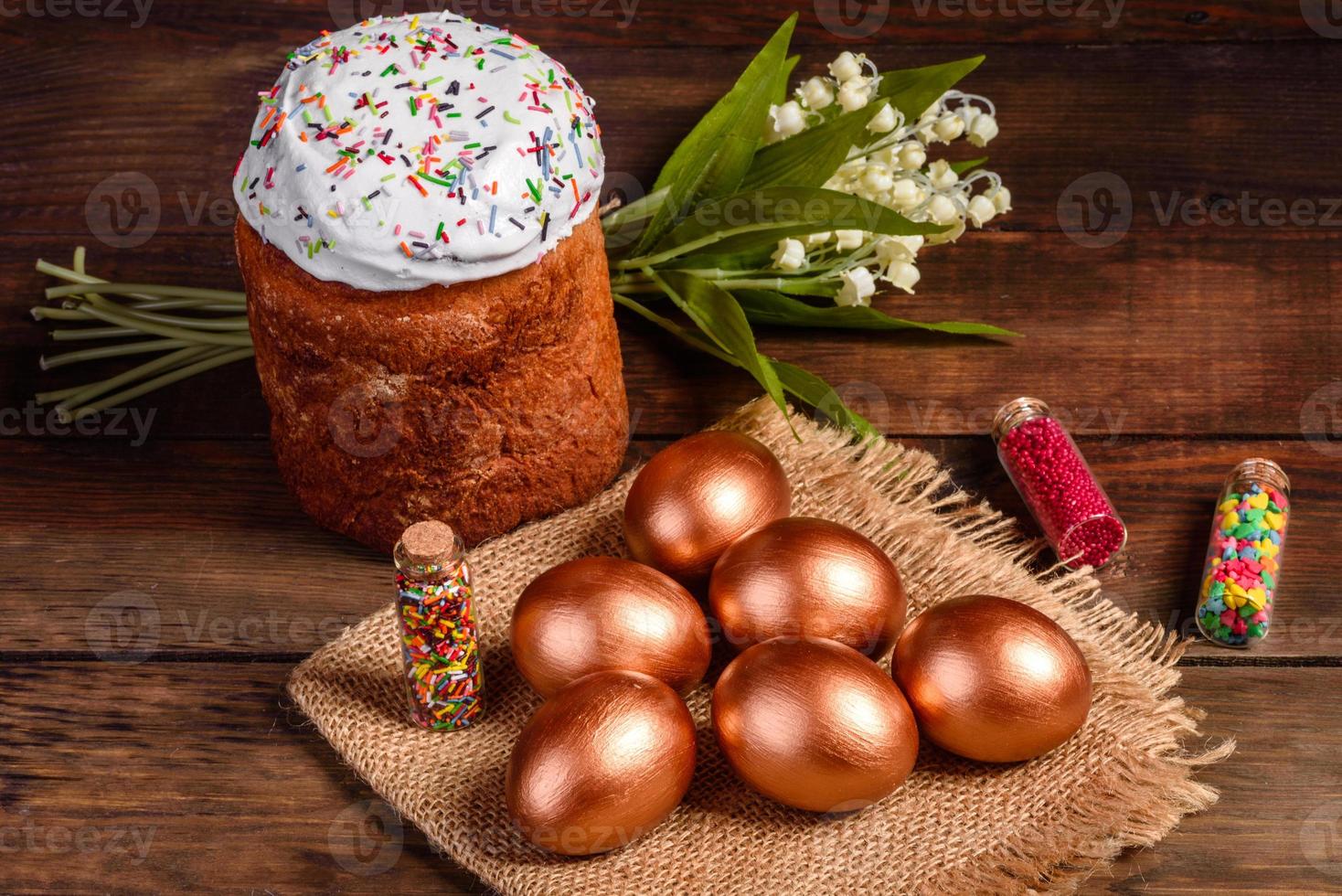 uova di pasqua oro e bronzo e torta di pasqua su sfondo scuro foto