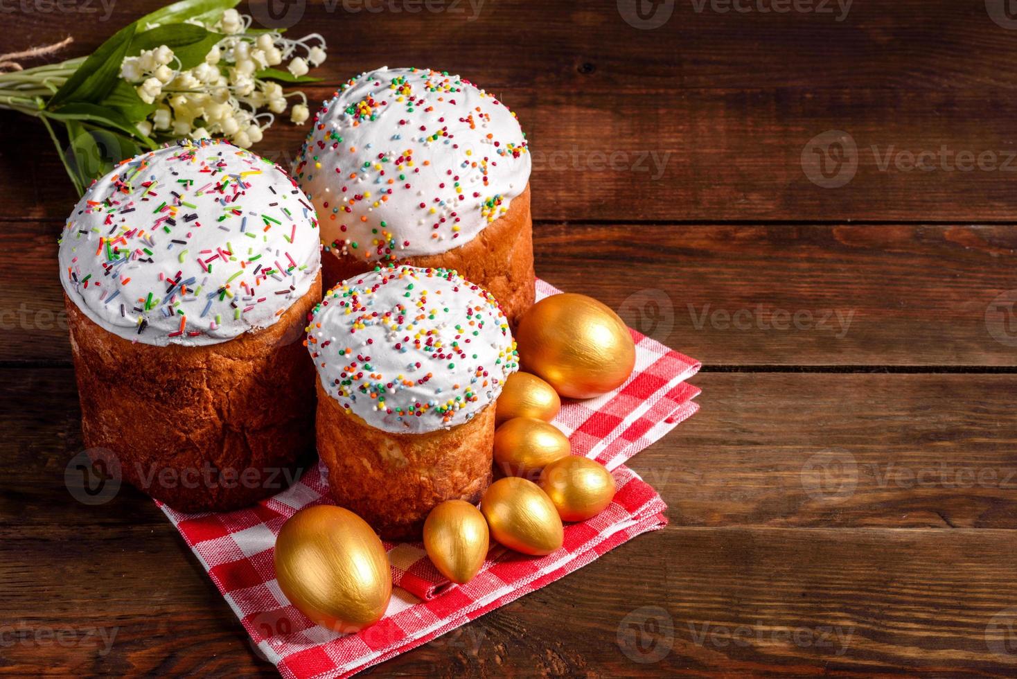 uova di pasqua oro e bronzo e torta di pasqua su sfondo scuro foto