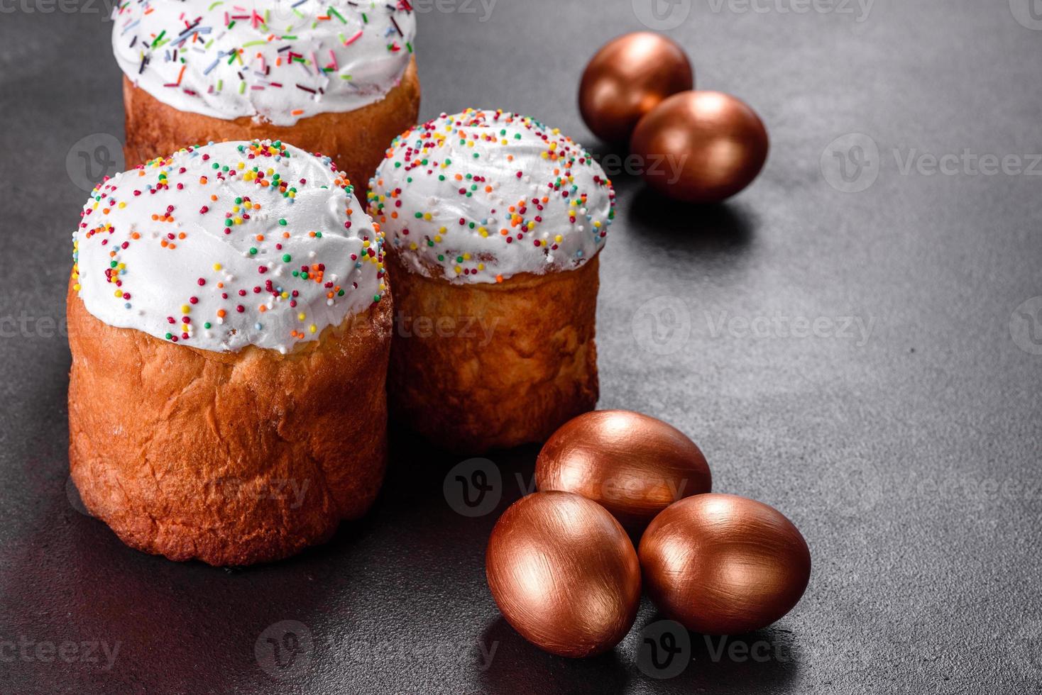 uova di pasqua oro e bronzo e torta di pasqua su sfondo scuro foto