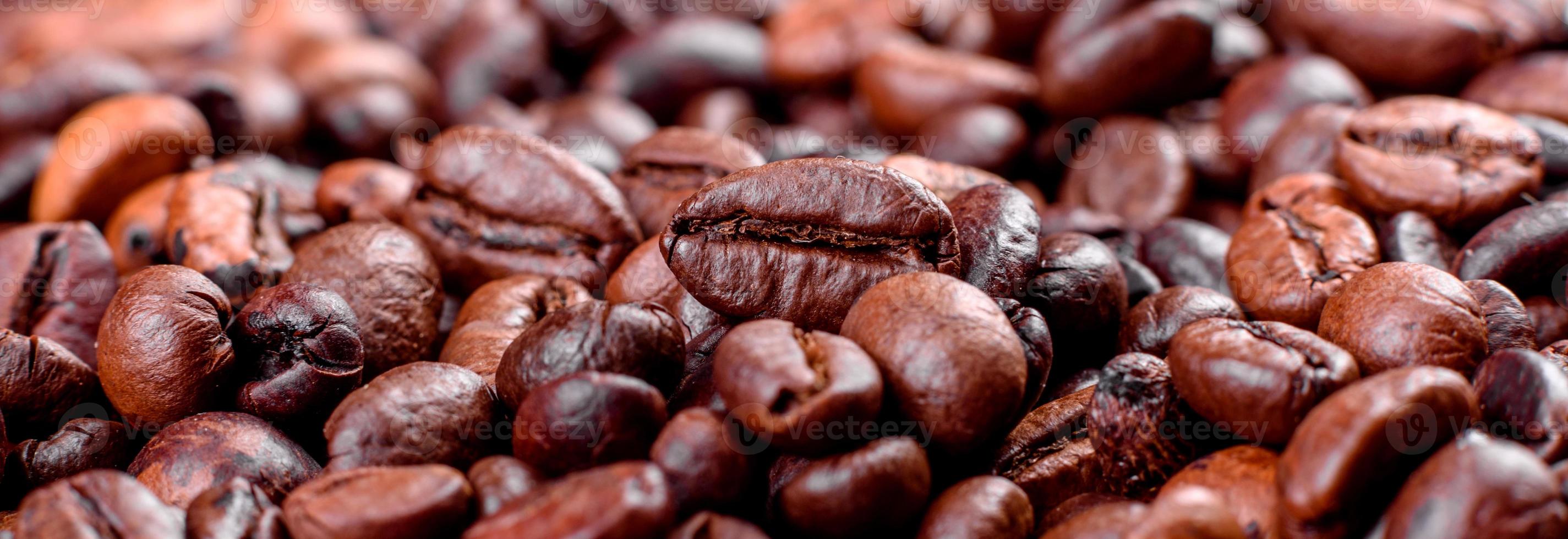 chicchi di caffè tostato fresco primo piano su uno sfondo scuro foto