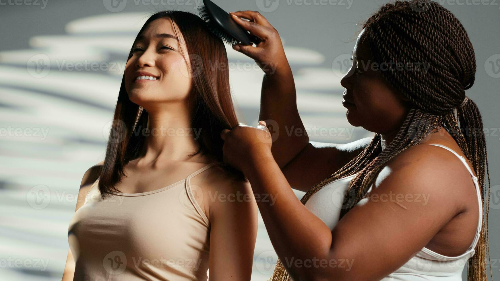 diverso donne ridendo e spazzolatura capelli nel studio, avendo divertimento come amici e mostrando corpo accettazione. giovane diverso ragazze con diverso tonalità della pelle e corpo tipi, cura della pelle campagna. foto