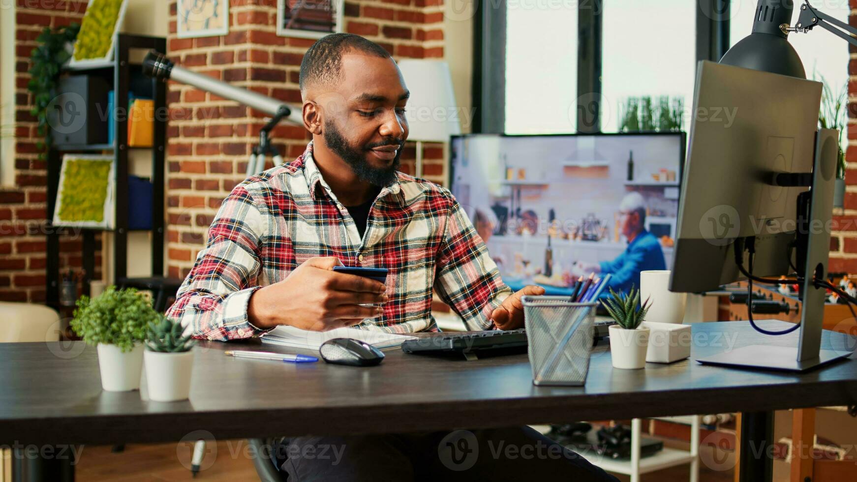 contento uomo eccitato su fare in linea acquisti, accuratamente digitando credito carta informazione su computer. africano americano aggiungendo pagamento metodo su sito web mentre nel accogliente elegante caldo casa foto