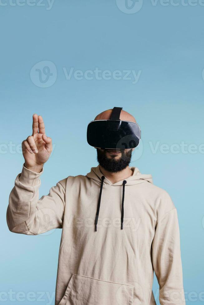 uomo indossare vr sedile di testa mentre giocando virtuale la realtà gioco e Esprimere a gesti con Due dita. giovane persona godendo metaverso e cyberspazio simulazione esplorazione Esperienza foto