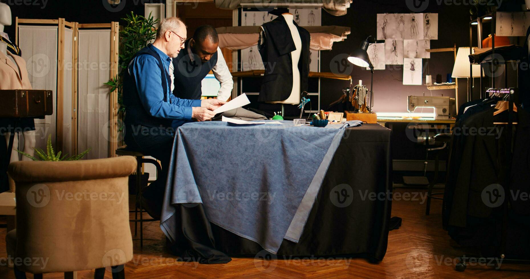 artigiano e apprendista fabbricazione schema per design moda collezione, principiante apprendimento di Abiti fatto a mano e sartoria industria. esperto vecchio couturier insegnamento alunno. palmare sparo. foto