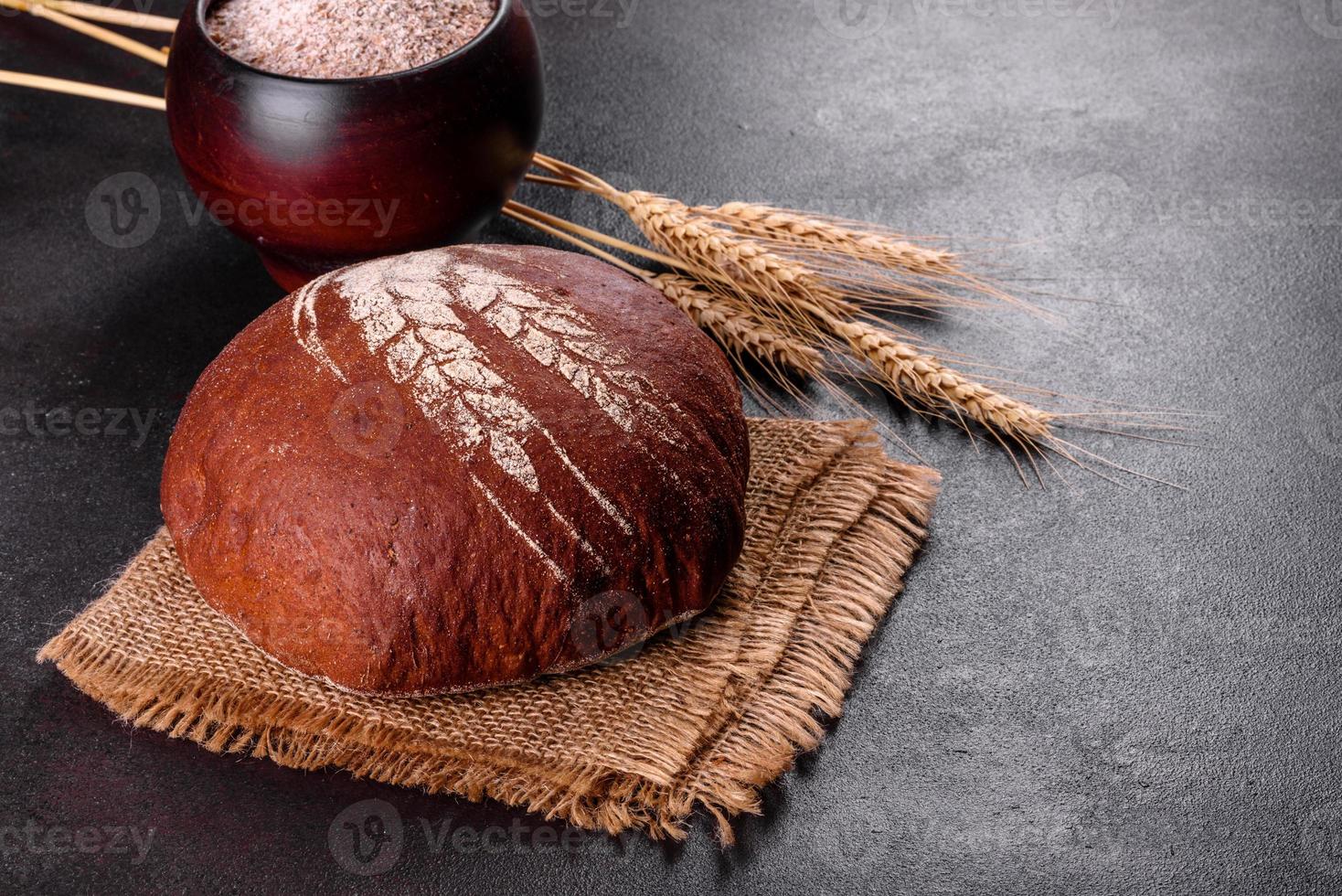 pane nero appena sfornato su uno sfondo di cemento marrone foto