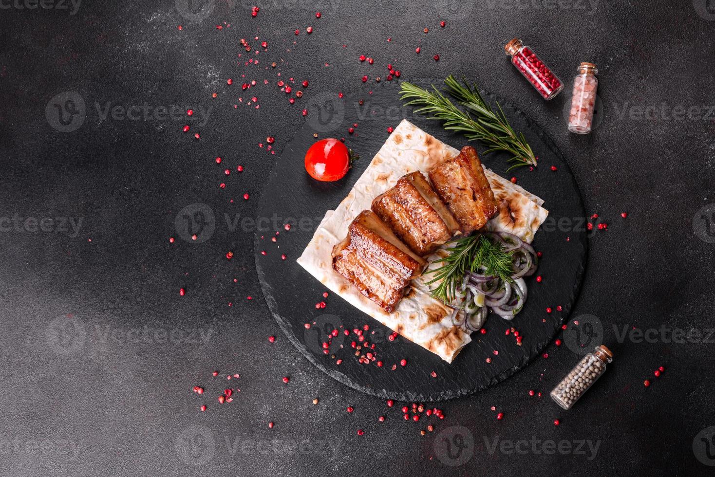 costine fritte con rosmarino, cipolla, salsa su un fondo di cemento foto