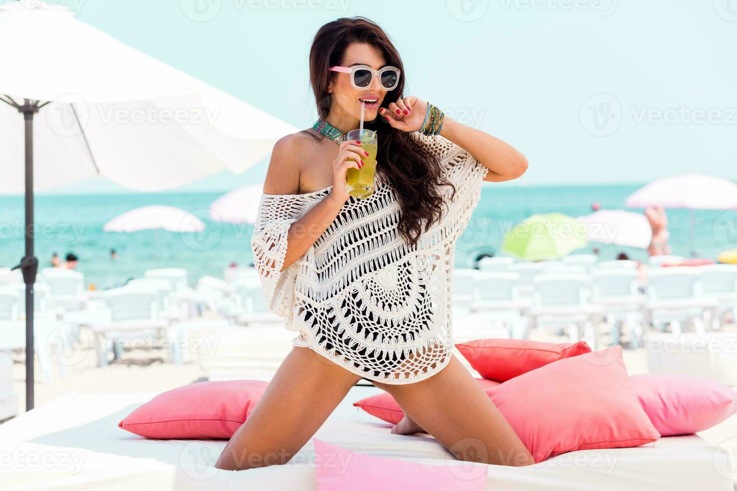 estate ritratto di bellissimo brunetta donna chilling nel il spiaggia club. tropicale accessori. foto