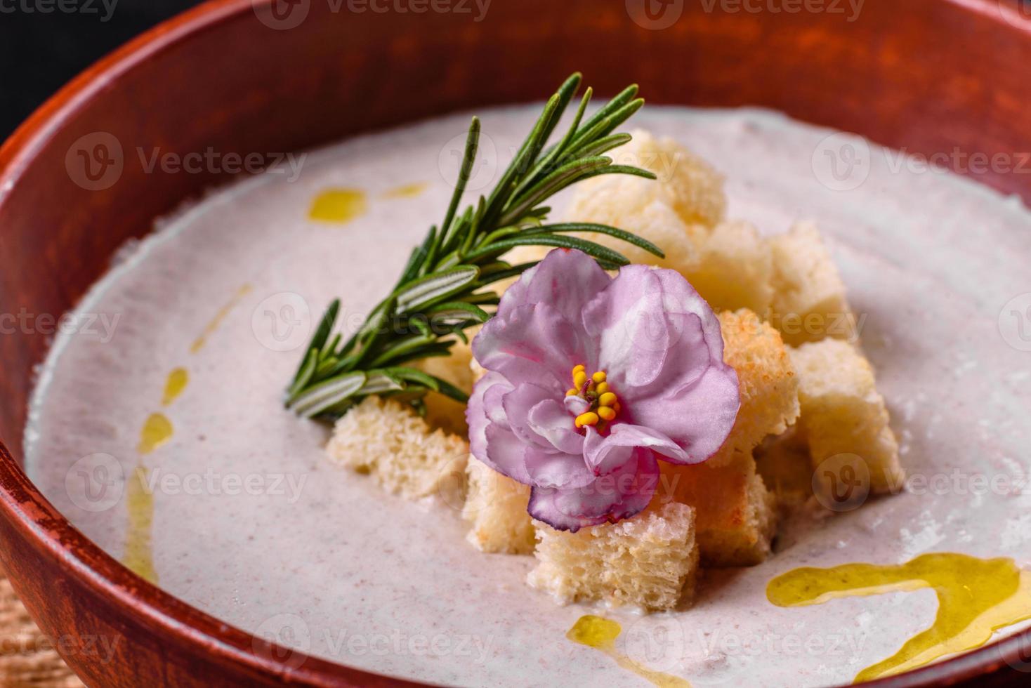 deliziosa zuppa di funghi in un piatto marrone con un cucchiaio di legno foto