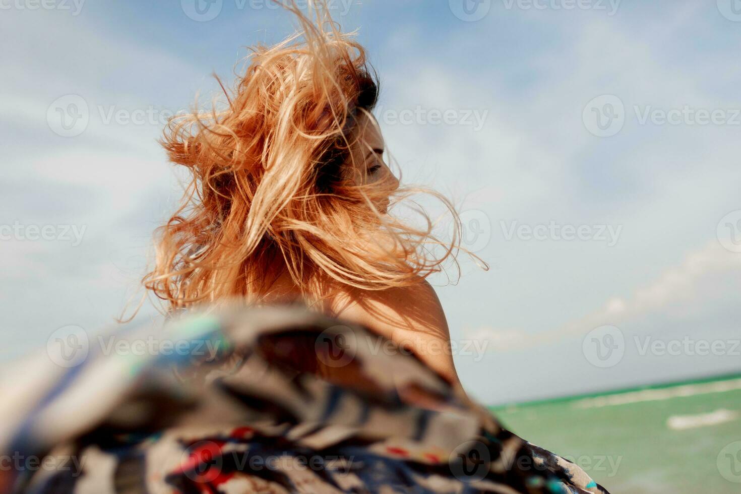 spensierato donna salto la libertà su bianca sabbia. blu oceano sfondo. ventoso capelli. foto