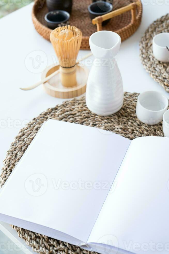 libro modello design. vuoto bianca libro su cenare tavolo nel asiatico stile con vasellame foto