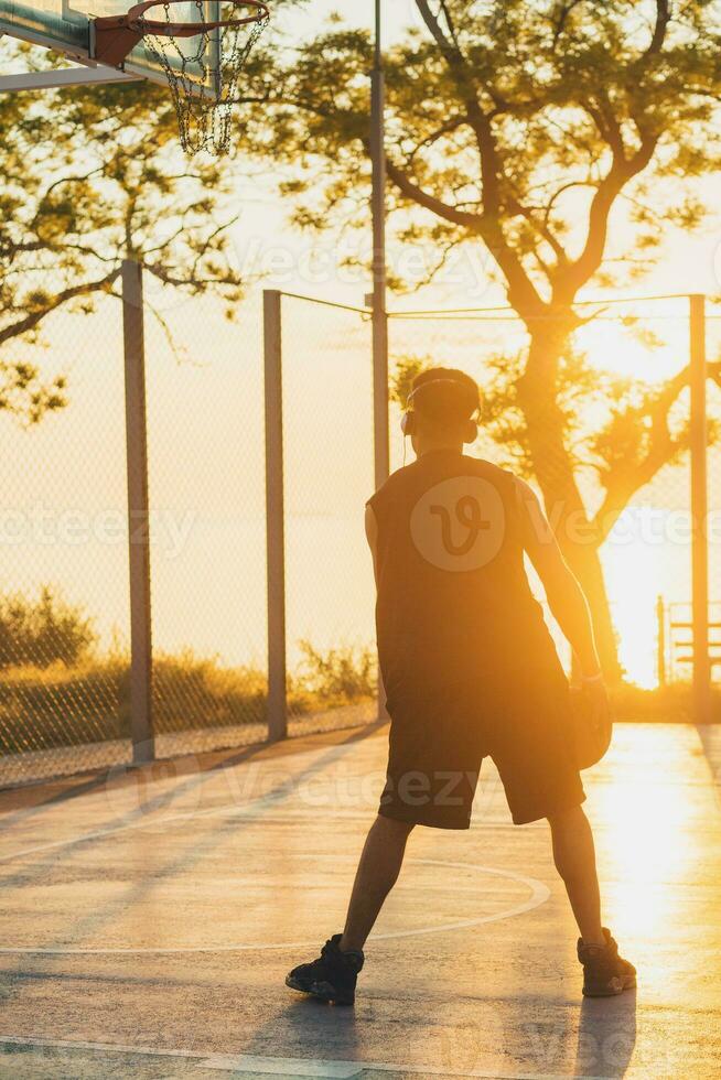 nero uomo fare gli sport, giocando pallacanestro su Alba, attivo stile di vita, soleggiato estate mattina foto