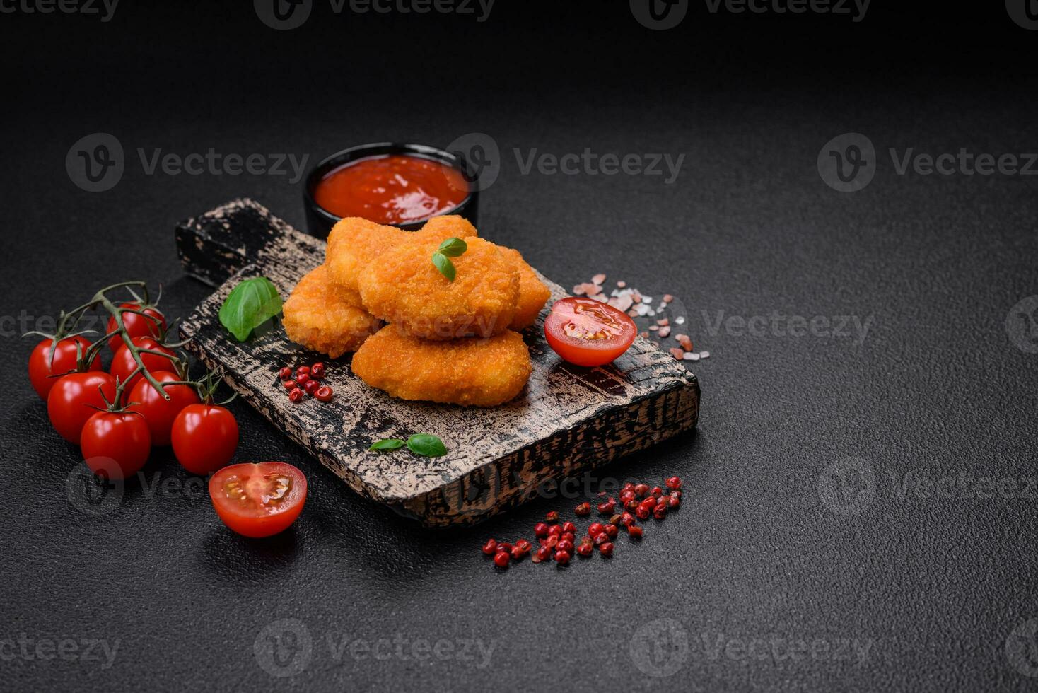 delizioso fresco croccante pollo pepite su un' buio calcestruzzo sfondo foto