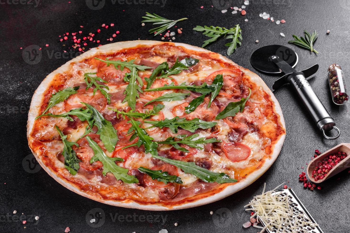 pizza fresca al forno con rucola, salame foto