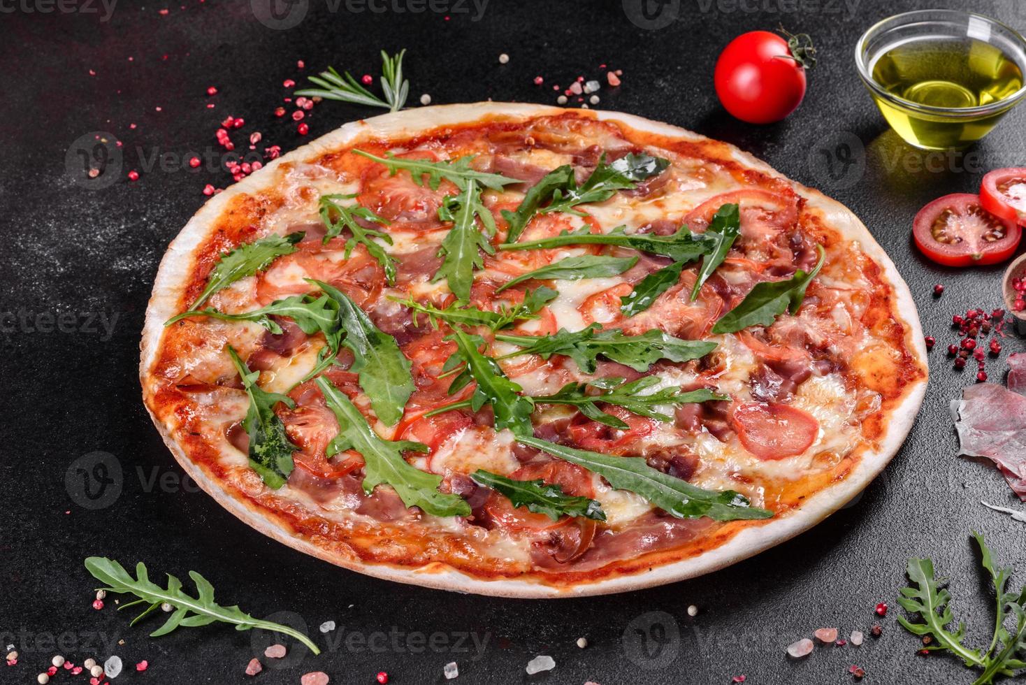 pizza fresca al forno con rucola, salame foto