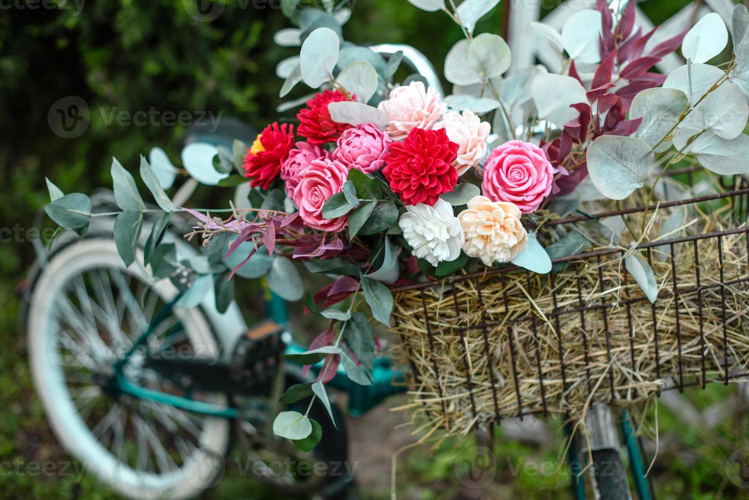 bella bicicletta con fiori in un cesto si erge su un viale foto