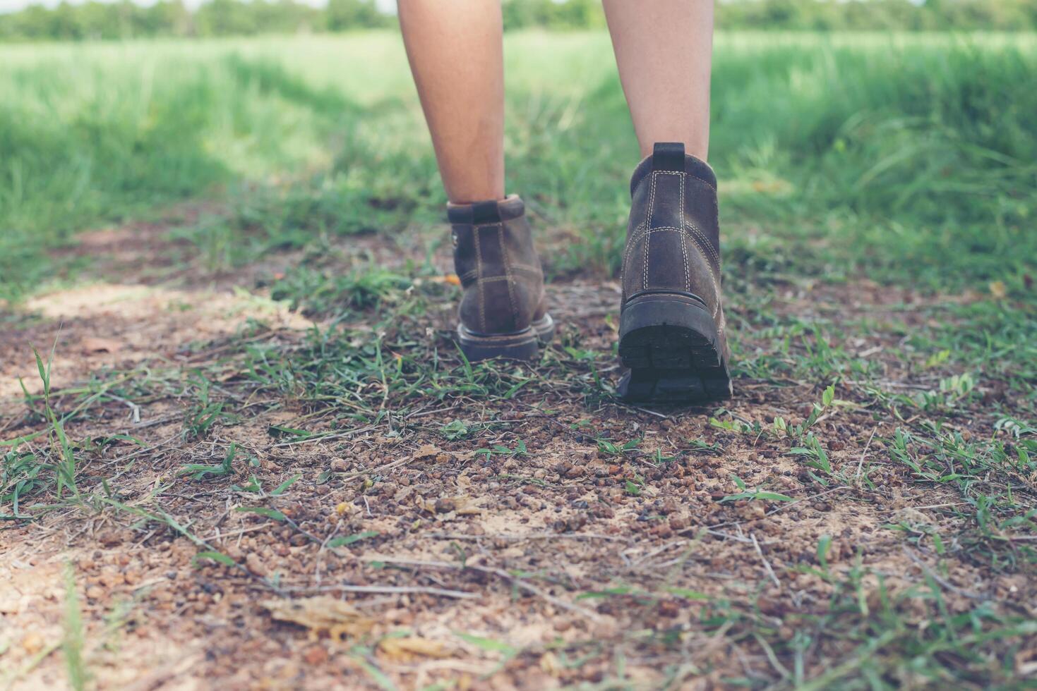 piedi di donna giovane avventura camminando sulla ghiaia in campagna. foto