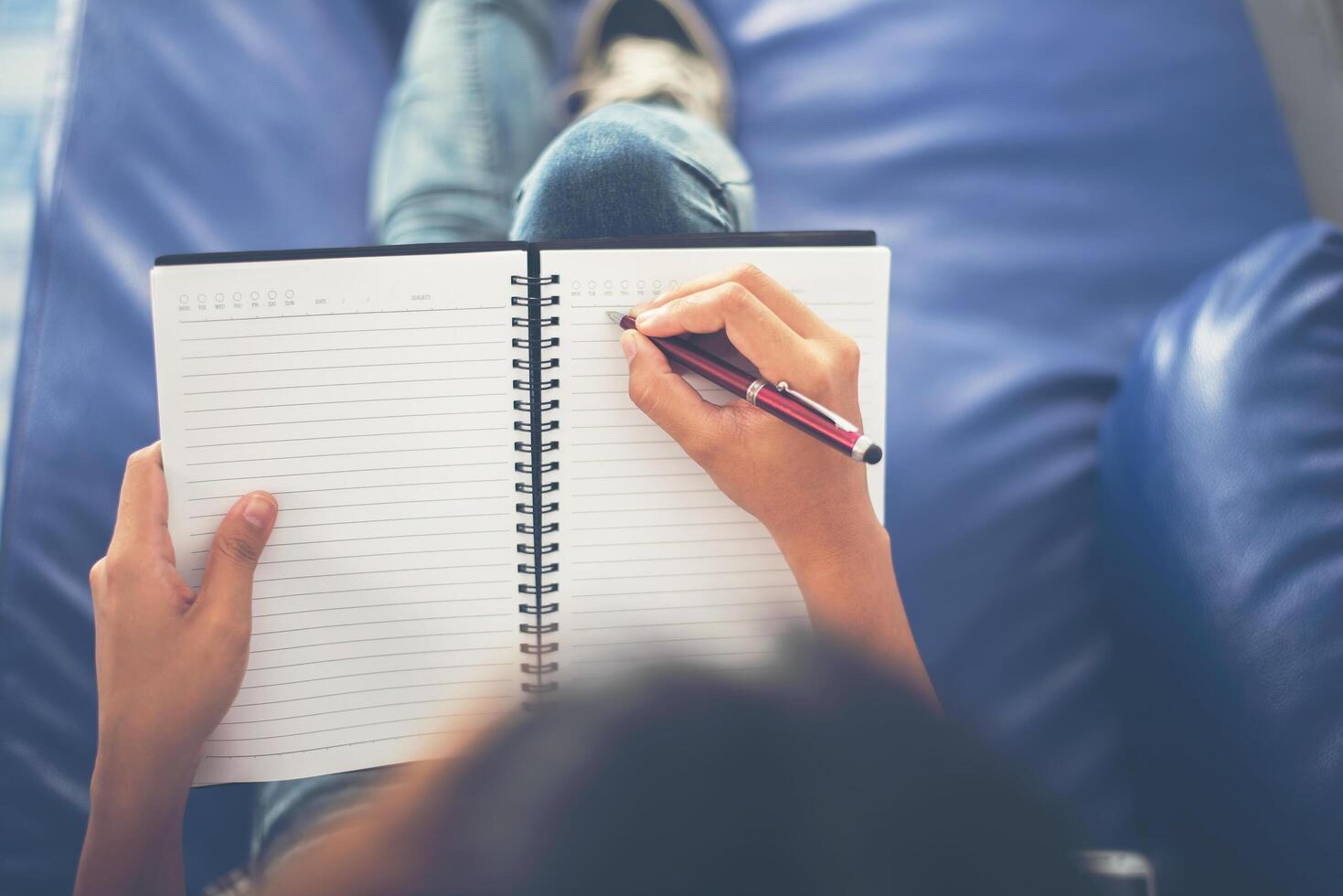 mani della donna che scrivono sul blocco note che si trova a casa. foto