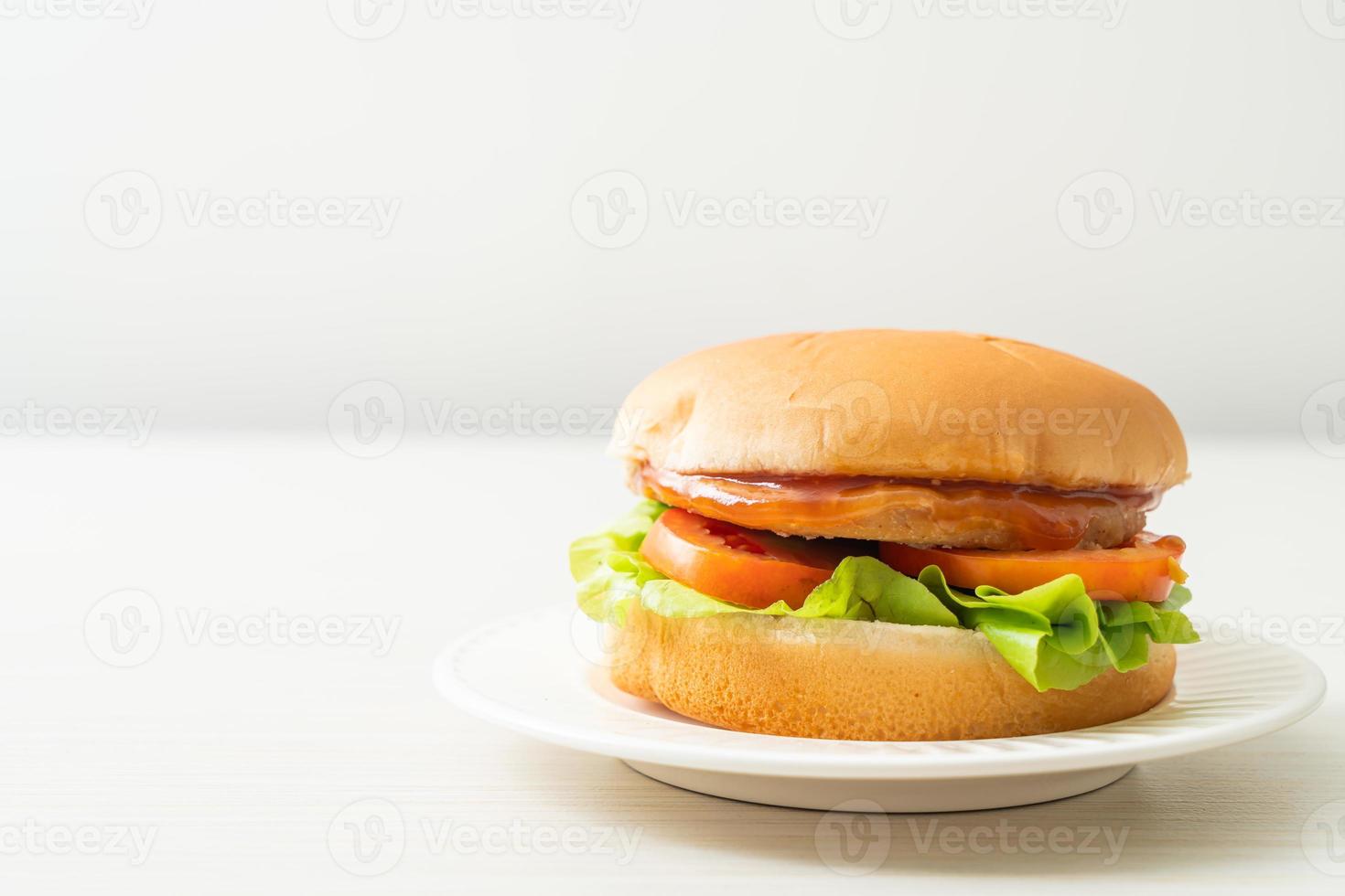 hamburger di pollo con salsa su piatto bianco foto