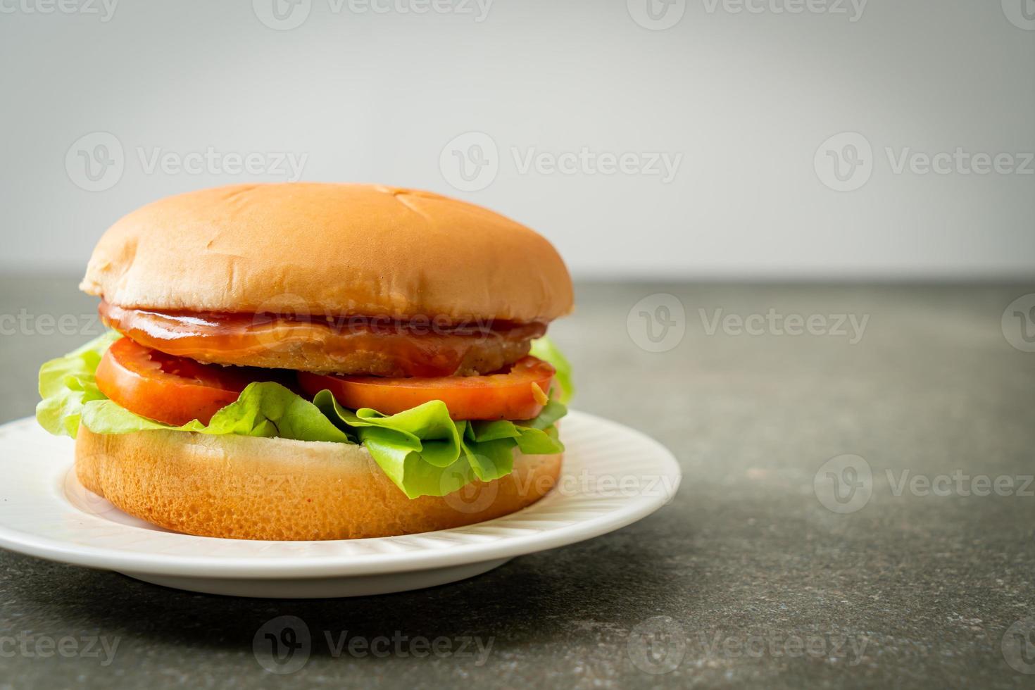 hamburger di pollo con salsa su piatto bianco foto