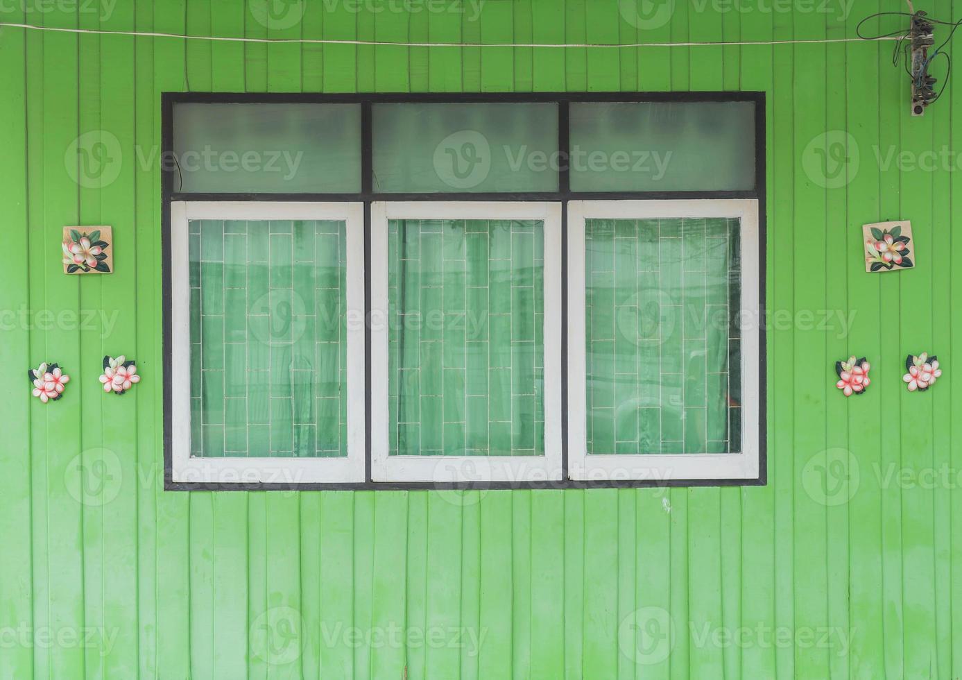vecchia finestra sul muro di legno verde foto