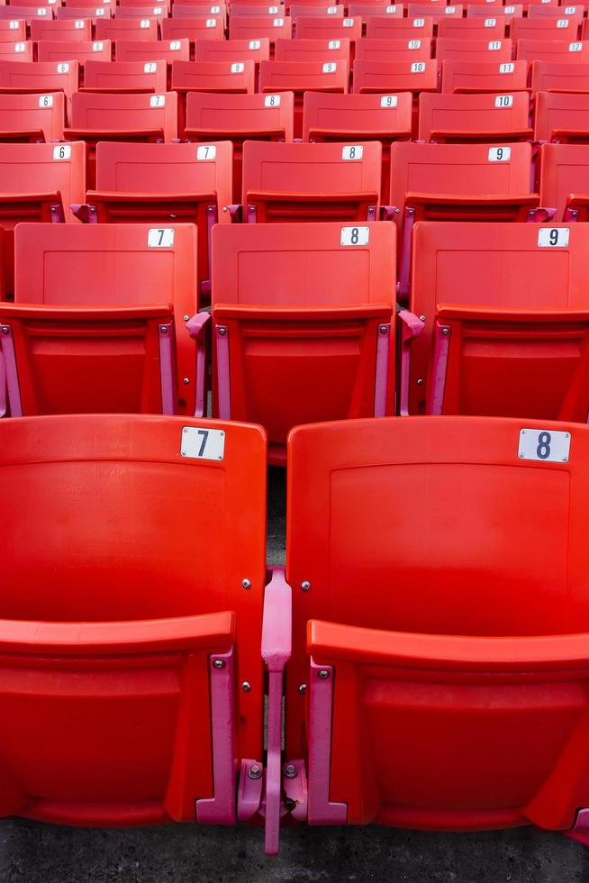 fila di sedie pieghevoli rosse in uno stadio. foto