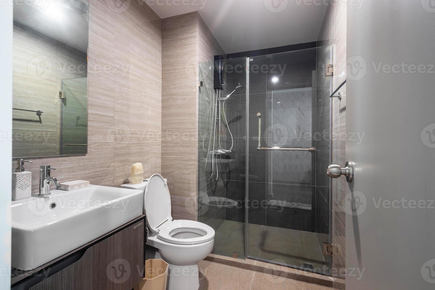 bagno moderno bianco e legno con cabina doccia in vetro in appartamento foto