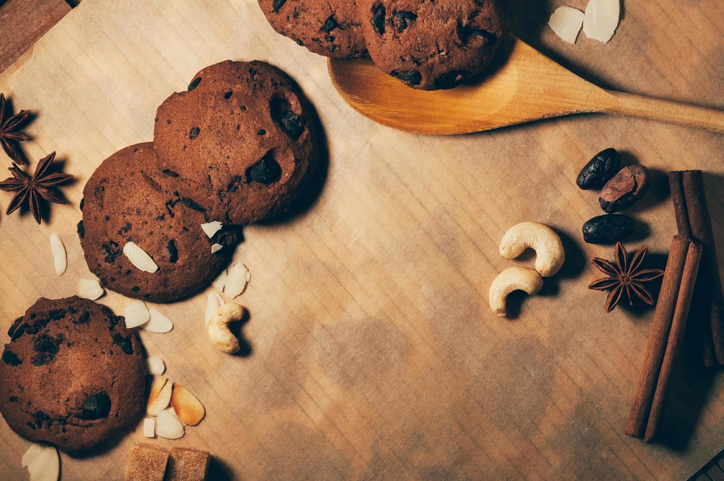 biscotti rotondi croccanti al cioccolato con cucchiaio di legno e spezie foto