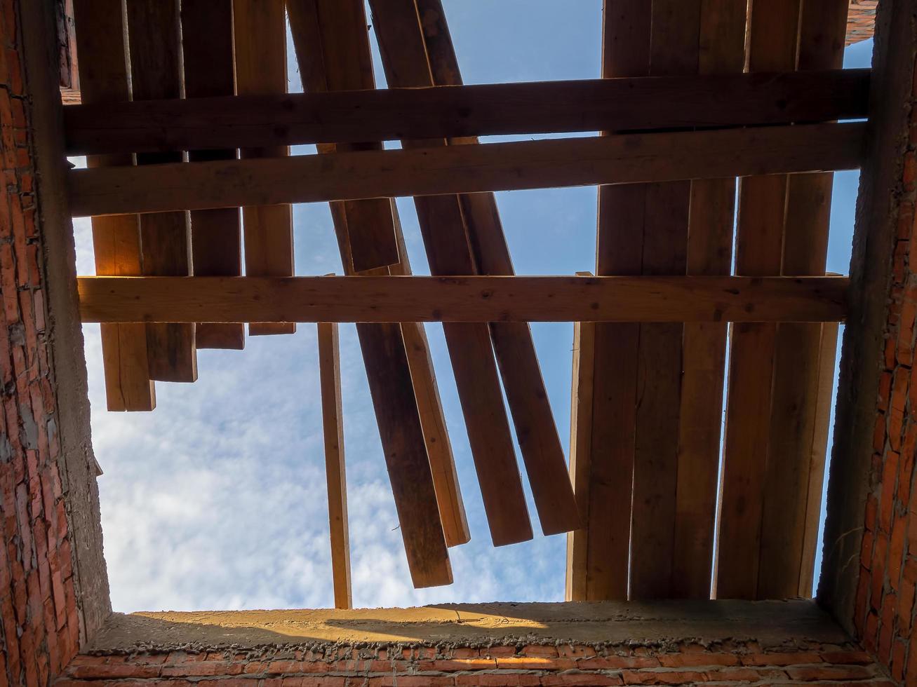 costruzione del tetto, vista dall'interno su cielo nuvoloso blu foto