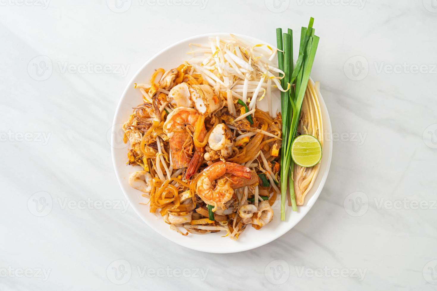 frutti di mare pad thai - tagliatelle saltate in padella con gamberi, calamari o polpo foto