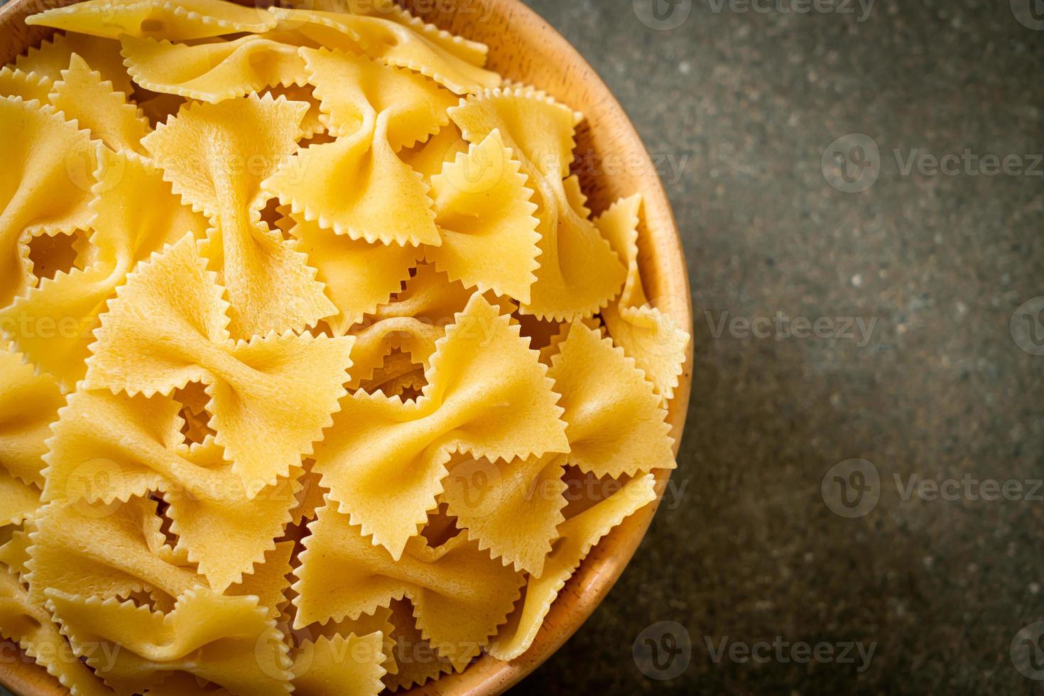 pasta secca di farfalle crude in una ciotola foto