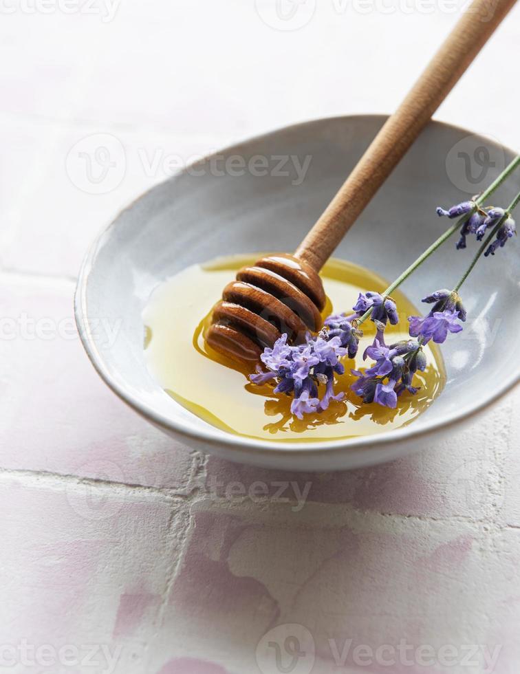 ciotola con miele e fiori di lavanda fresca foto