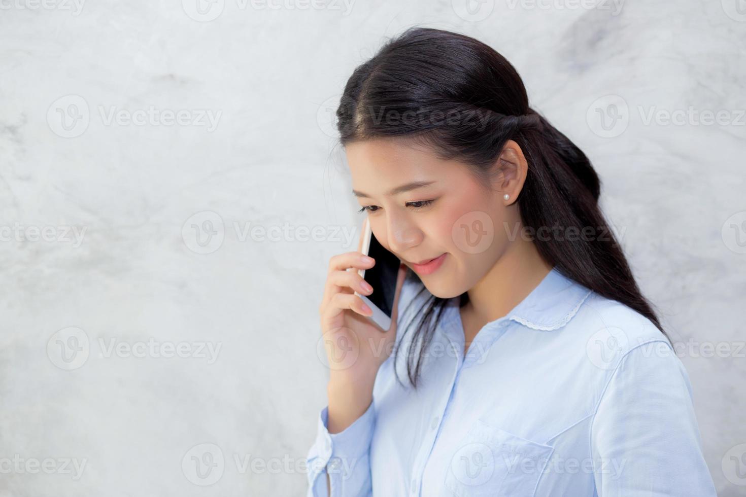 giovane donna asiatica che parla smart phone foto