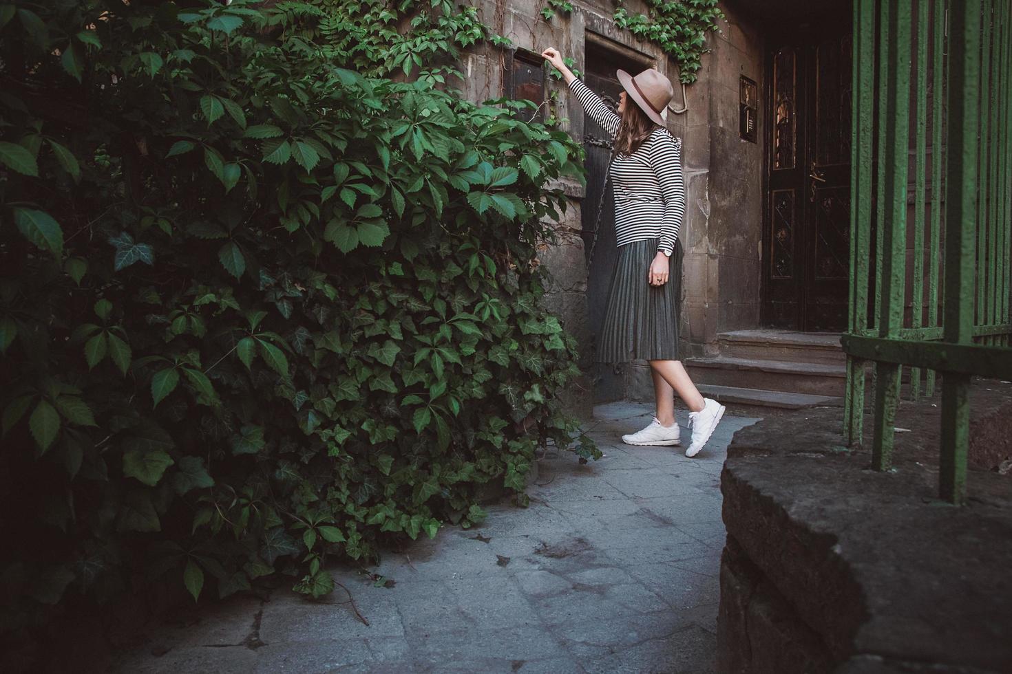 la ragazza con il cappello apre una cassetta delle lettere sullo sfondo della vecchia casa foto