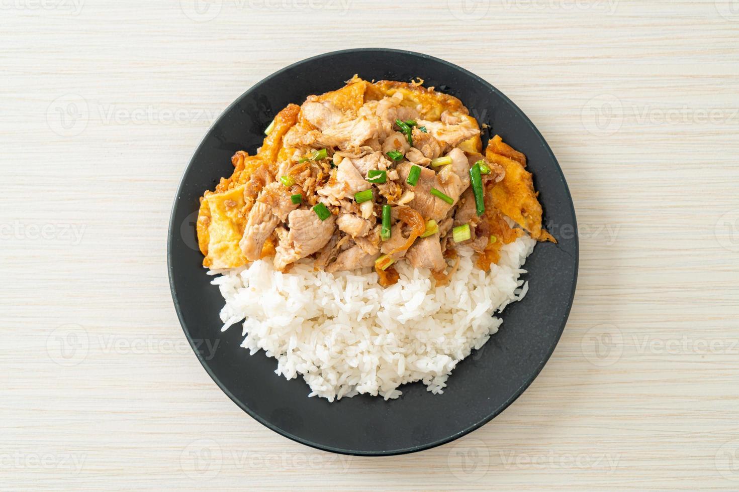 maiale saltato in padella con aglio e uova ricoperte di riso - stile asiatico foto